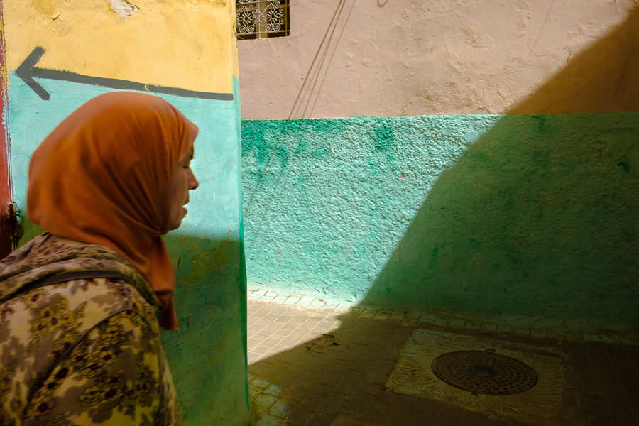Streets of Morocco Lady walking in lanes with shadow and colors - Captivating Street Photography by Giancarlo Zuccarone
