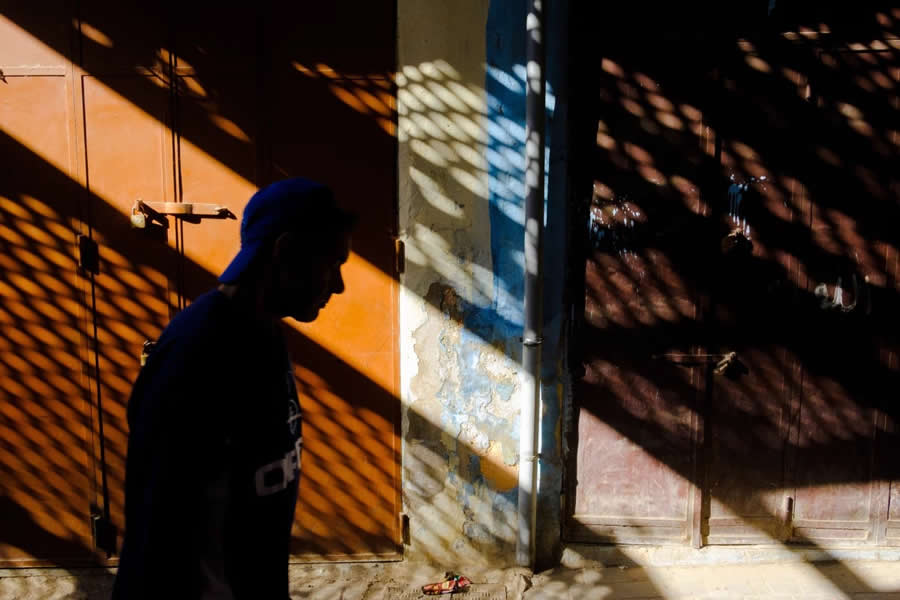 Man Walking on street with long shadows and colors - Captivating Street Photography by Giancarlo Zuccarone