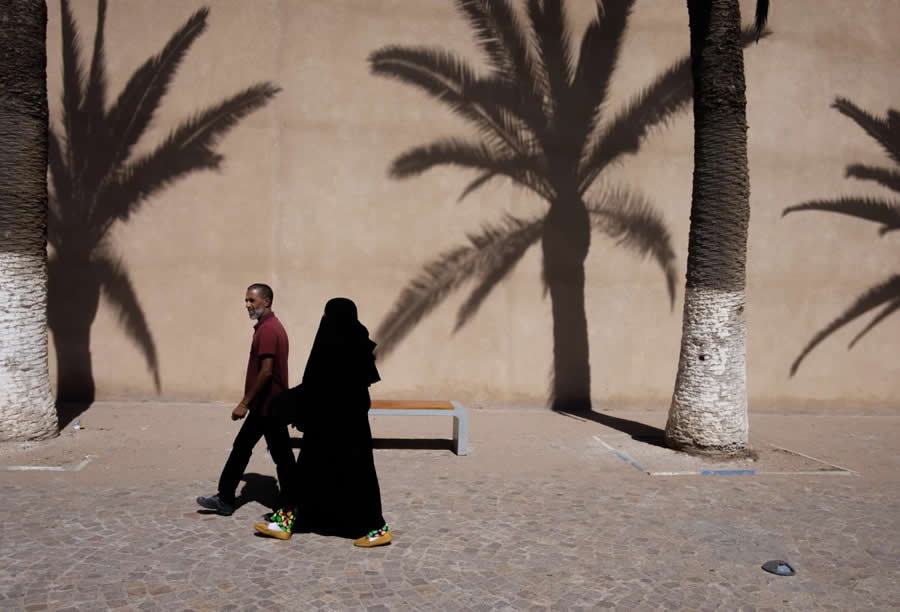 Morocco Street Scene with trees and shadows Man and Woman Walking - Captivating Street Photography by Giancarlo Zuccarone