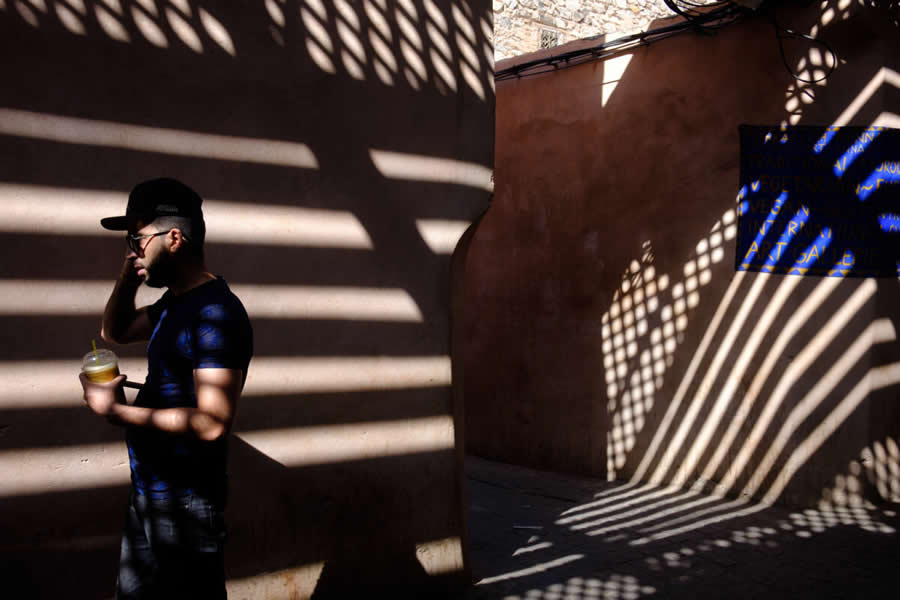 Man Walking on street with long shadows and colors - Captivating Street Photography by Giancarlo Zuccarone