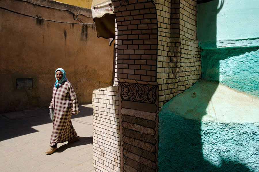 Lady Walking on streets of Morocco nice composition with patters of walls and shadows - Captivating Street Photography by Giancarlo Zuccarone