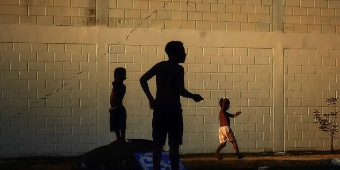 Nikon Film and Photo Contest 2025: A Celebration of Creativity and Human Inspiration 26 Children's silhouettes flying a red kite against a brick wall