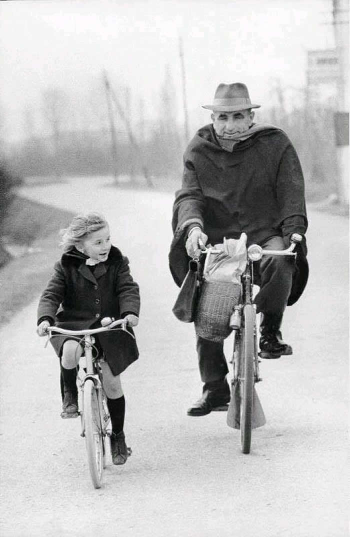 Girl riding a bicycle with her grandfather - Black and White Bicycle Photos of Everyday Life