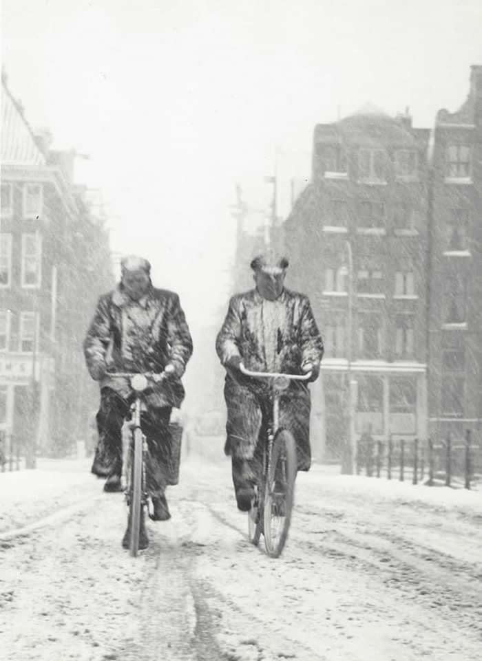 Two men cycling together through the snow - Black and White Bicycle Photos of Everyday Life