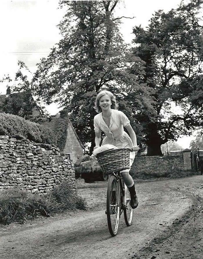 Girl cycling through a rural village - Black and White Bicycle Photos of Everyday Life