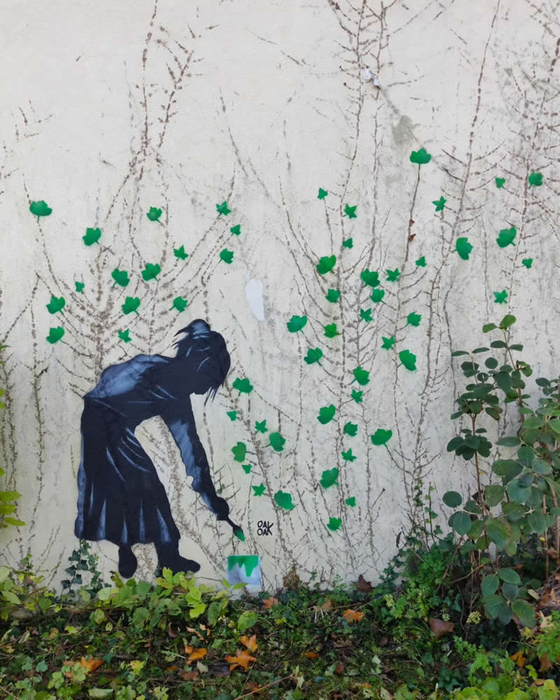 A little girl painting green leaves on wall - Funny Creative Street Artworks by Oak Oak