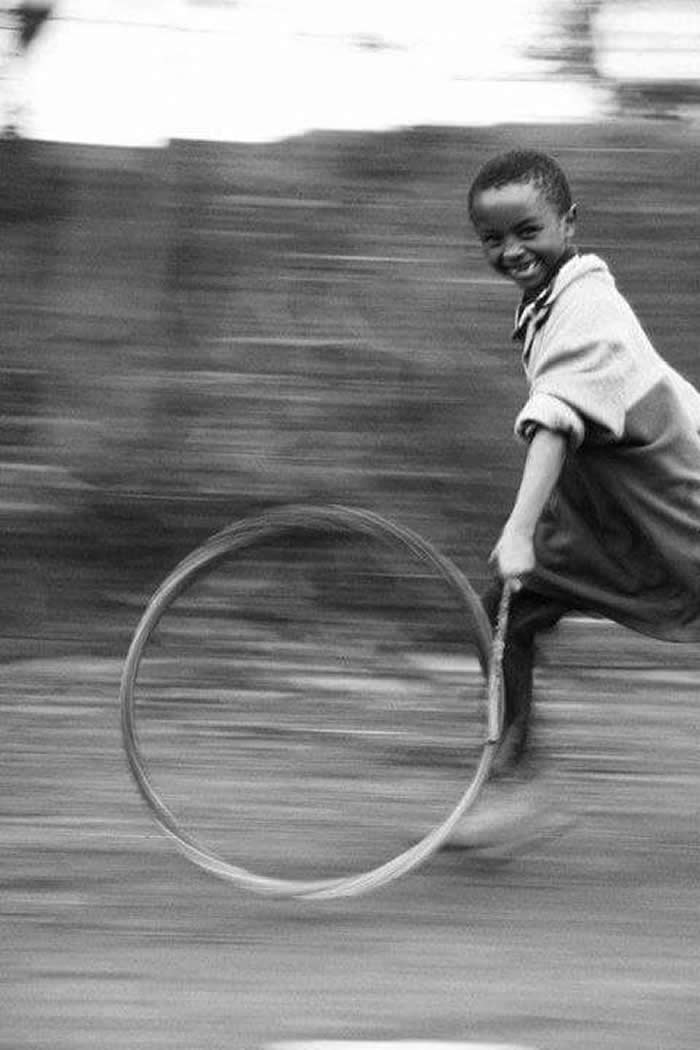 Boy playing with a tire - Pure Joy of Childhood Black and White Photos