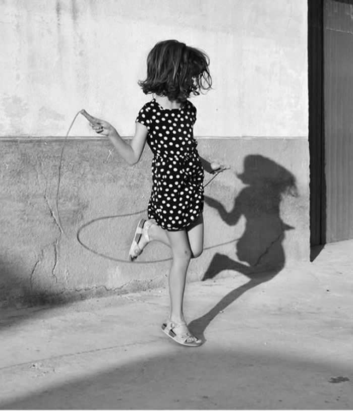 Girl jumping with her shadow reflecting on the wall - Pure Joy of Childhood Black and White Photos