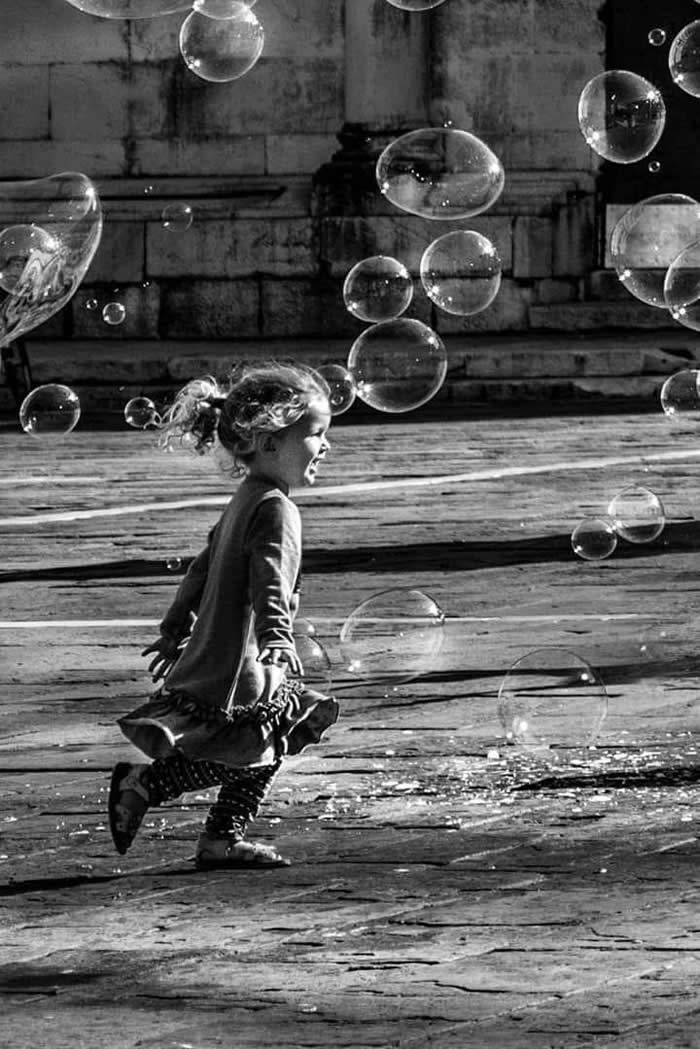 Girl running toward water bubbles - Pure Joy of Childhood Black and White Photos