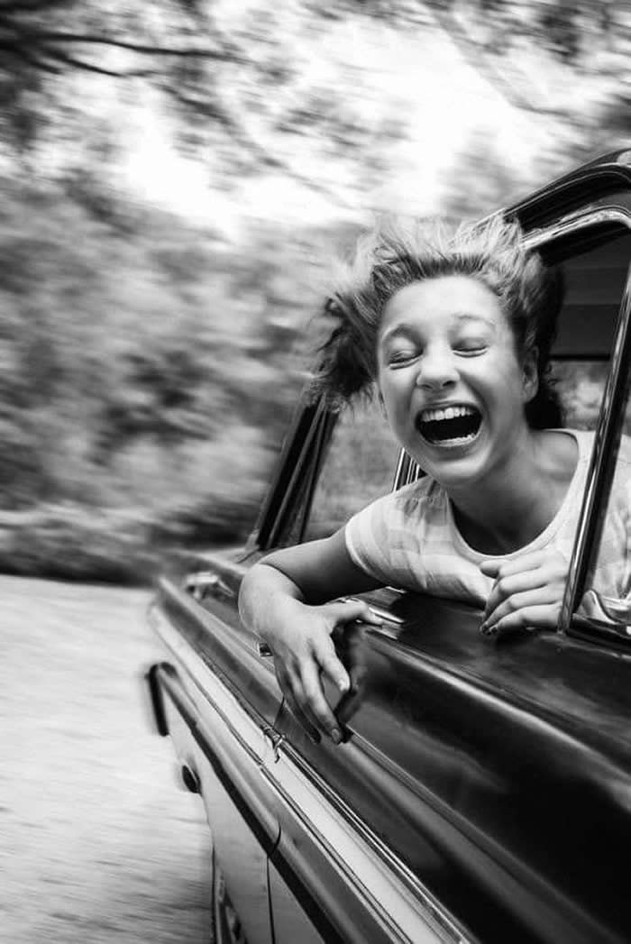 Girl laughing through a car window, enjoying the speed - Pure Joy of Childhood Black and White Photos