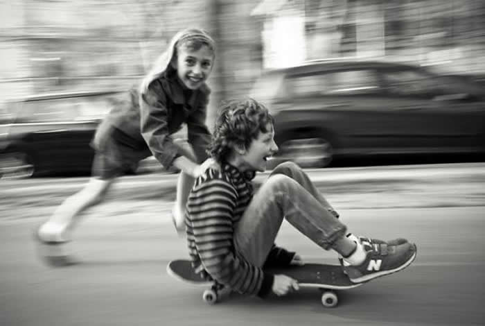 Brother and sister playing with a bicycle - Pure Joy of Childhood Black and White Photos