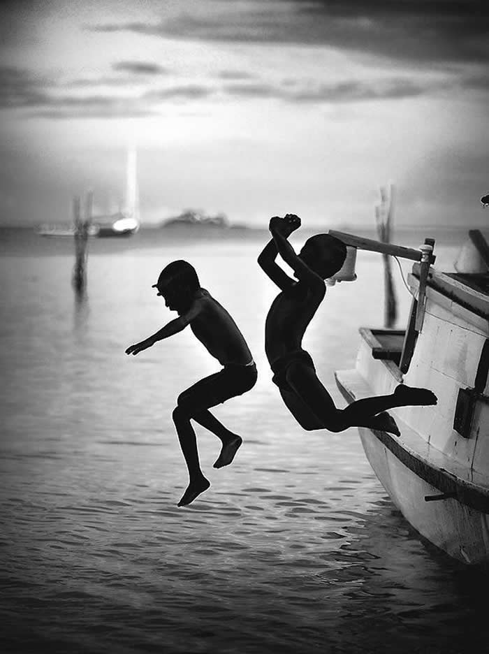 Two boys jumping into a river - Pure Joy of Childhood Black and White Photos