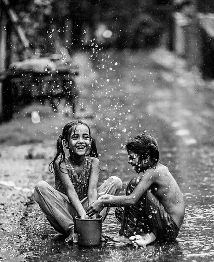 Two kids playing in the rain - Pure Joy of Childhood Black and White Photos