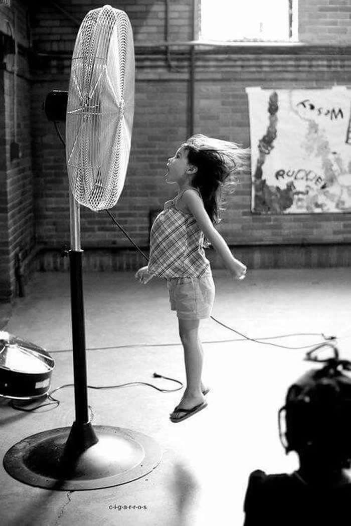 Girl jumping near a fan - Pure Joy of Childhood Black and White Photos