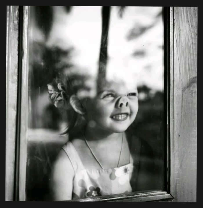 Girl playing by the window — a fine art portrait - Pure Joy of Childhood Black and White Photos