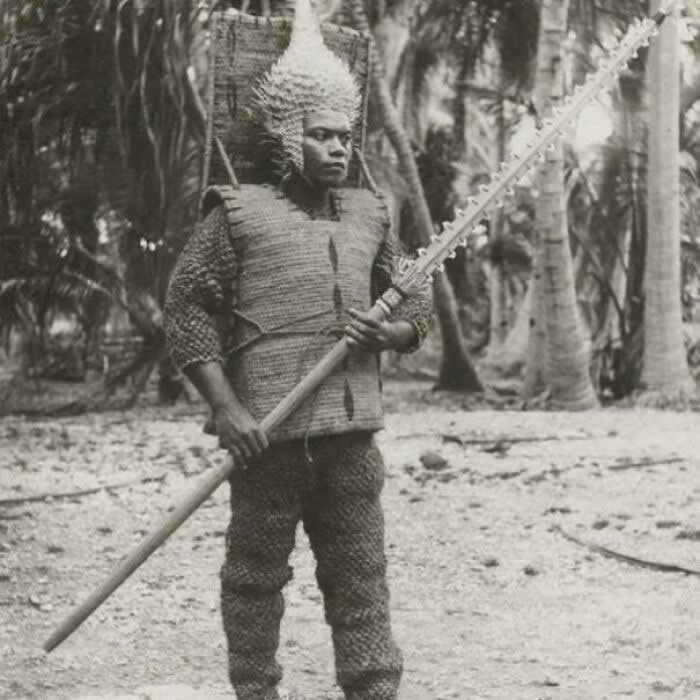 A Kiribati Warrior From Beru Wearing A Suit Of Armor Made From The Tough Outer Fibers Of Coconut Husks, A Helmet Of Dried Pufferfish, And Holding A Shark Tooth Spear - Rare Historical Photos Stories Behind the Past