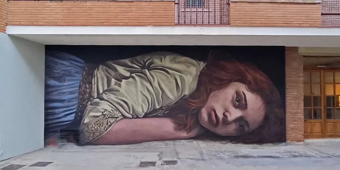 A giant mural of a woman lying down painted across a building's garage facade