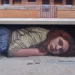 A giant mural of a woman lying down painted across a building's garage facade