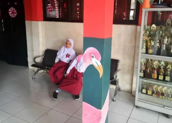 Indonesian schoolgirl resting on bench