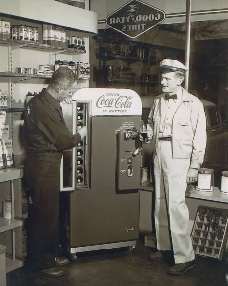 25 Powerful Historical Photos That Bring Forgotten Stories Back to Life 47 A Coca-Cola delivery man filling a Coca-Cola machine while a Shell station attendant stands holding a cola and watching. Terre Haute, Indiana, 1957. - Powerful Historical Photos