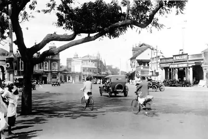 Madras (Chennai), 1930s – a peaceful street scene with early cars, bicycles, and colonial-era buildings - Rare Historical Vintage Indian Photos