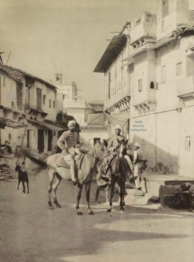 Udaipur — Street with horsemen, 1928. A quiet city lane where riders pass through the heart of historic Udaipur, offering a glimpse of everyday life in the late 1920s - Rare Historical Vintage Indian Photos