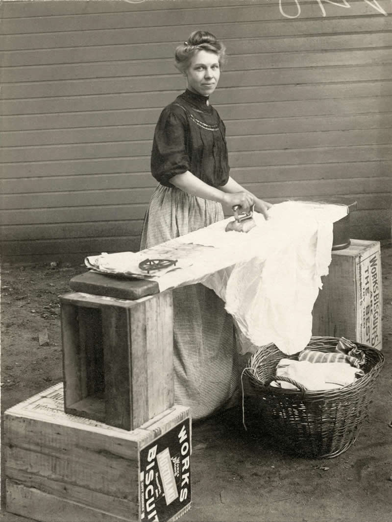 Woman ironing clothes, Minneapolis, Minnesota, USA, circa 1910. The recommended starting point was soaking the garments overnight, followed by soaping, boiling or scalding, rinsing, ringing out, dying, starching, and finally ironing. - Rare Historical Photos That Bring Forgotten Moments