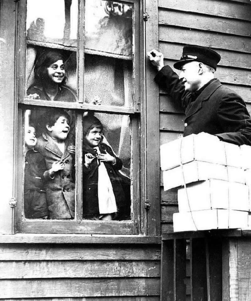 Children smile out a window as donated Christmas presents are delivered to their home. Detroit, Michigan, 1932 - History Forgotten Moments Unseen Photos