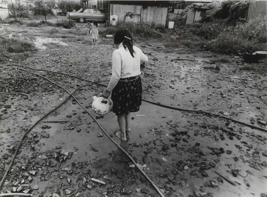 Barefoot girl in a puddle at an emergency shelter for Sinti and Roma in Mainz - Abisag Tullmann Master Legendary Photographer