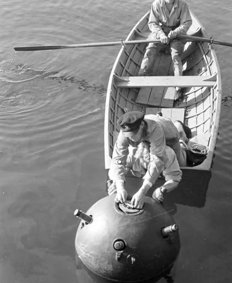 Finnish personnel disarm a floating sea mine from a small wooden rowboat in the Gulf of Finland near Haapasaari, Autumn 1944. Photo by SA-Kuva. - Old Photos That Capture Rare and Forgotten Moments in History
