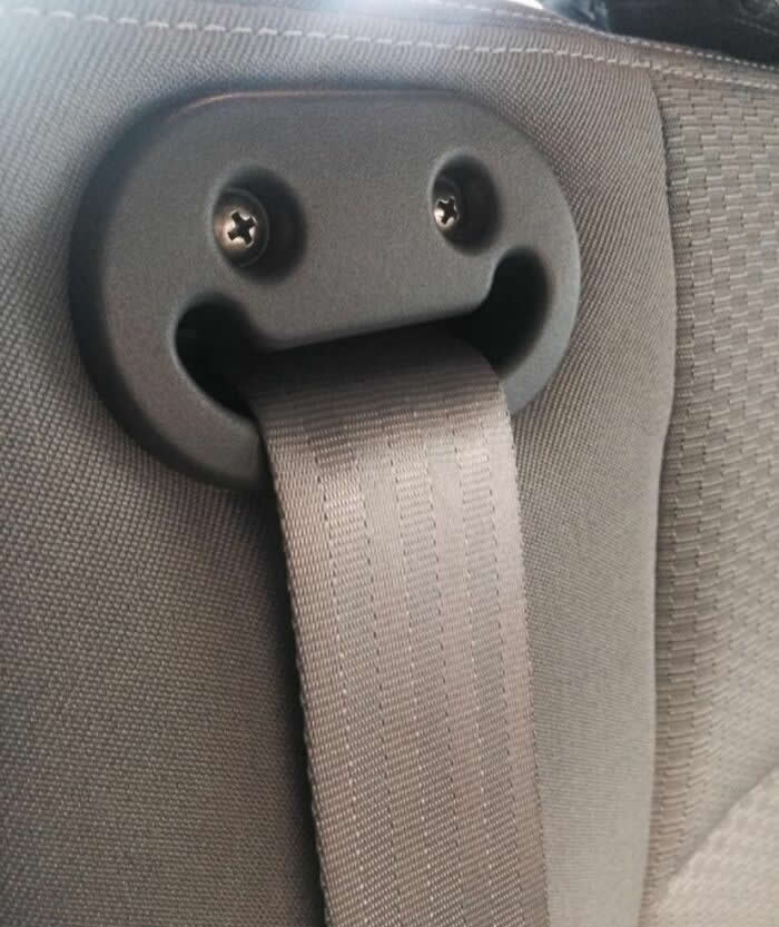 30 Public Objects Having a Total Meltdown 35 A car seat belt holder with two visible screws resembling eyes and the seat belt strap forming a tongue-like shape, creating a funny smiling face on the back of a vehicle seat.