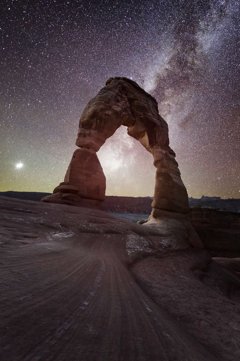Beyond the Stars: How Mads Peter Iversen Captures the Milky Way Like No One Else 39 Natural sandstone arch under the Milky Way galaxy with thousands of stars shining above a desert landscape at night.