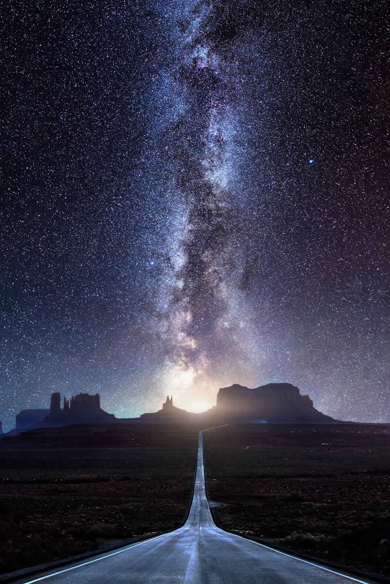 Beyond the Stars: How Mads Peter Iversen Captures the Milky Way Like No One Else 40 Long straight desert road leading toward distant mesas beneath a bright Milky Way galaxy filled with thousands of stars in the night sky.