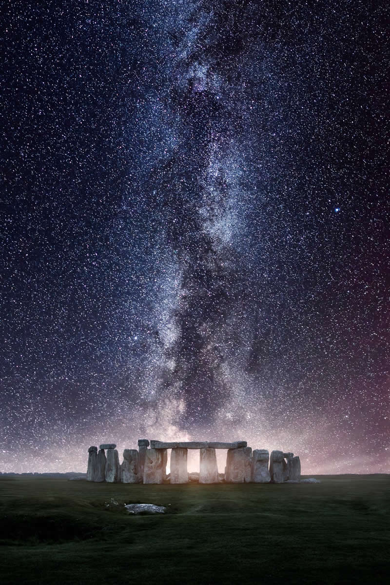 Beyond the Stars: How Mads Peter Iversen Captures the Milky Way Like No One Else 51 Stonehenge monument under the Milky Way galaxy with thousands of stars forming a bright vertical band above the ancient stone circle.