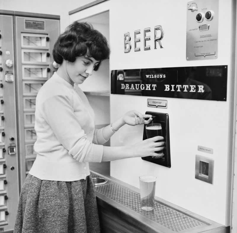 33 Unseen Photographs That Reframe American History 50 A woman getting a pint of draught bitter (beer) from a vending machine, 1962.