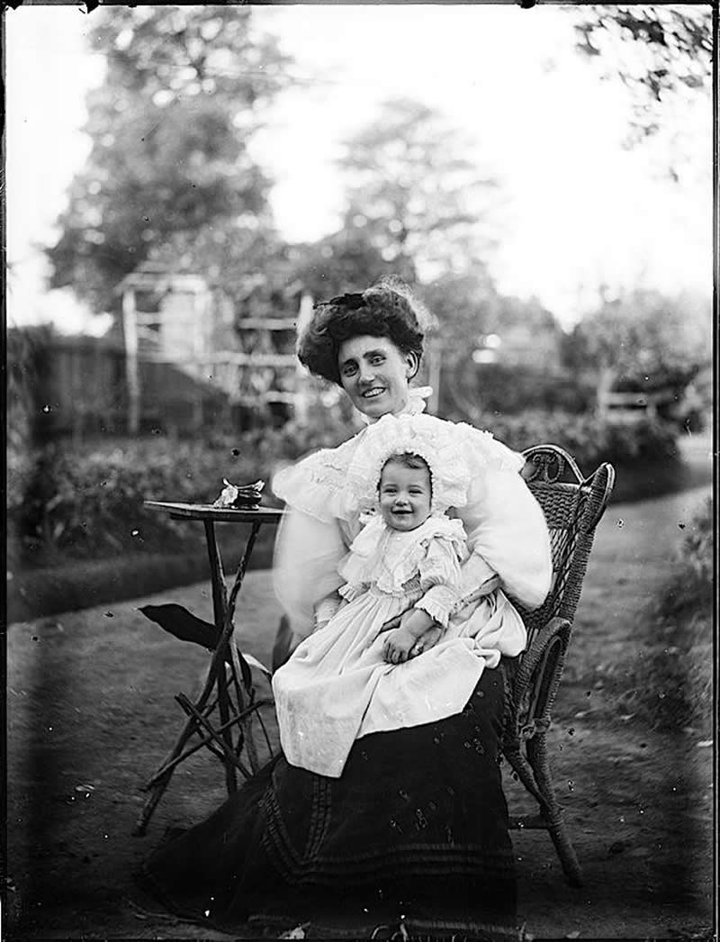 33 Unseen Photographs That Reframe American History 52 An old-time picture where people are smiling. A mother and her baby smiling for the camera in the early 1900s.