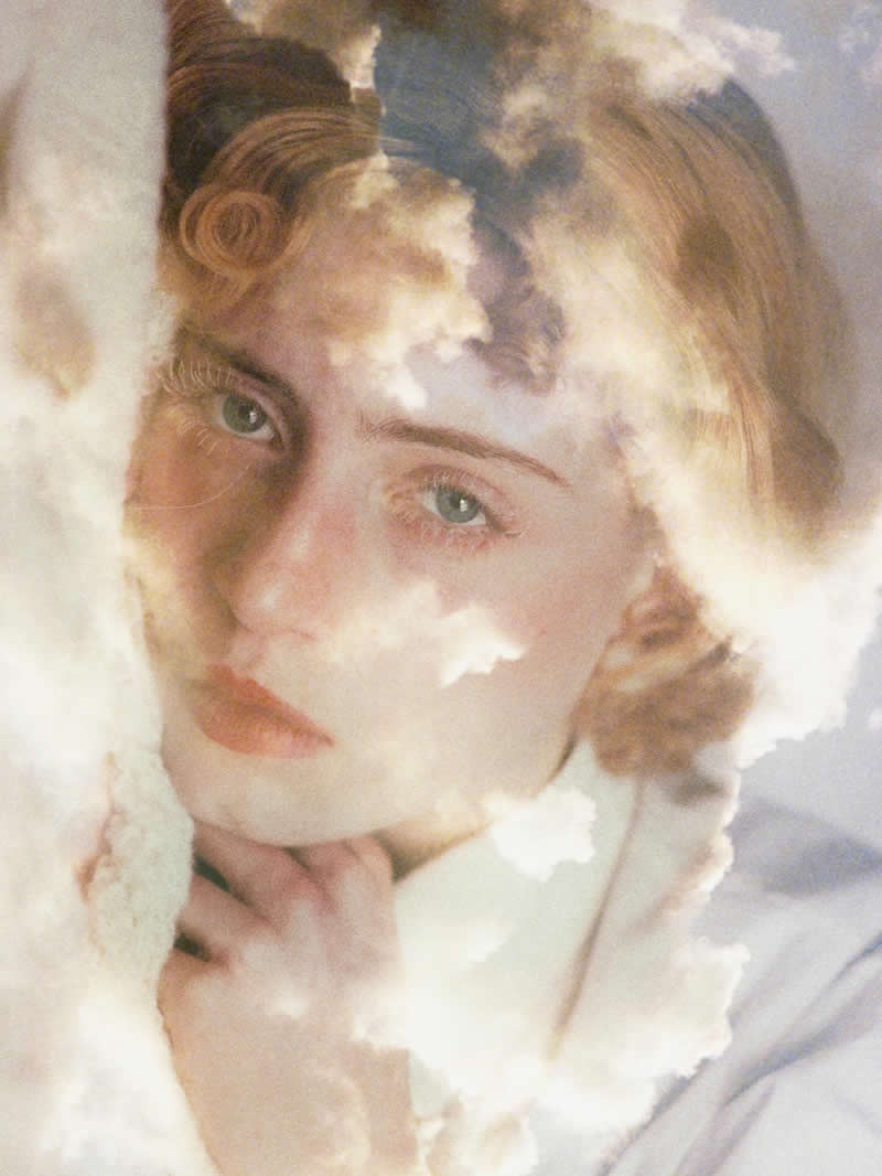 Soft-toned double exposure portrait of a woman with clouds blended across her face, creating a dreamy and surreal composition with gentle light and delicate textures.