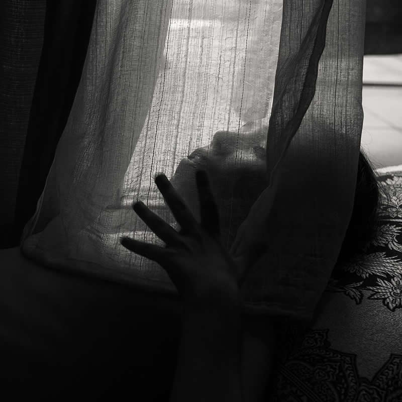Finalist: "A girl on the autism spectrum playing with a curtain" by Anna Reznikov - Life Frame Black and White Photo Contest Winners