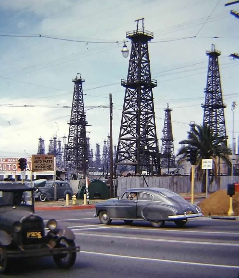 A Chevrolet and a Ford Model A driving through the oil fields of Signal Hill, Long Beach, California, 1952.