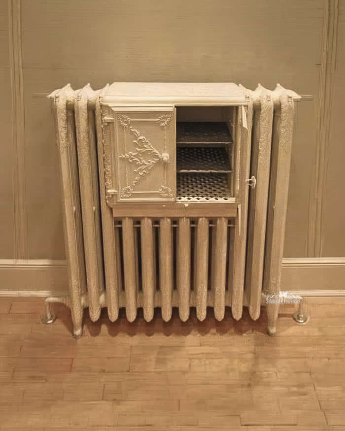 A late 19th-century radiator featuring an integrated warming oven. This ornate cast iron masterpiece was designed to keep plates warm and ready for service in grand Victorian dining rooms.