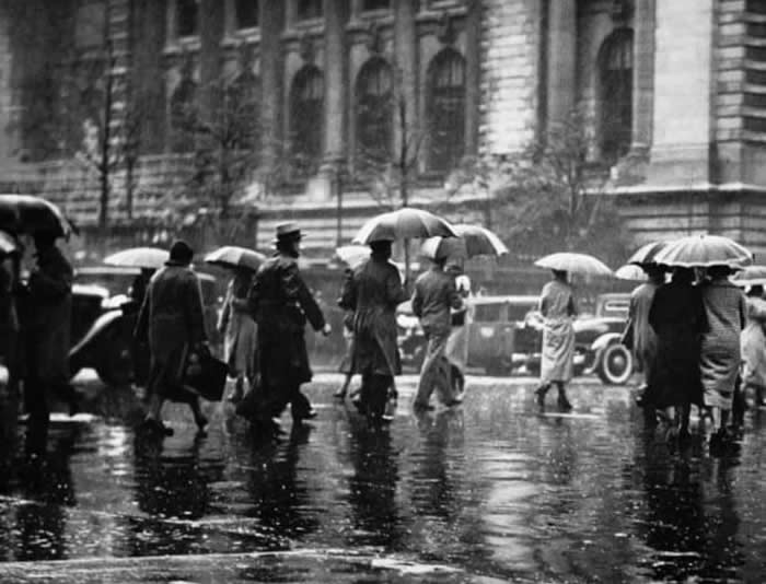 Resilient people walk through the wet streets of New York City during the challenging 1940s.