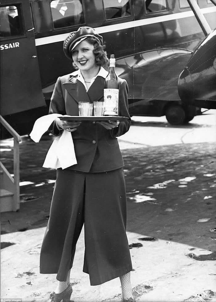 Swissair stewardess standing in front of a Curtiss T-32 Condor airliner at Tempelhof airport in Berlin, 1934. The Condor was the first European airliner to have a stewardess.