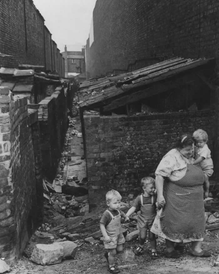 A mother and her children making their way through a back alley in the Liverpool slums in England, 1962.