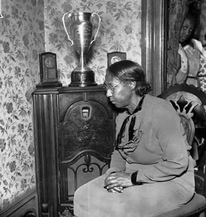 Proud mother, Mrs. Cleveland Owens, hears of son Jesse's Olympic triumphs in Berlin, 1936