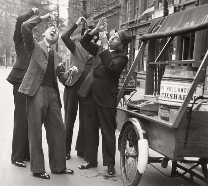 Customers eating herring in the traditional Dutch way. Netherlands, Rotterdam, 1937