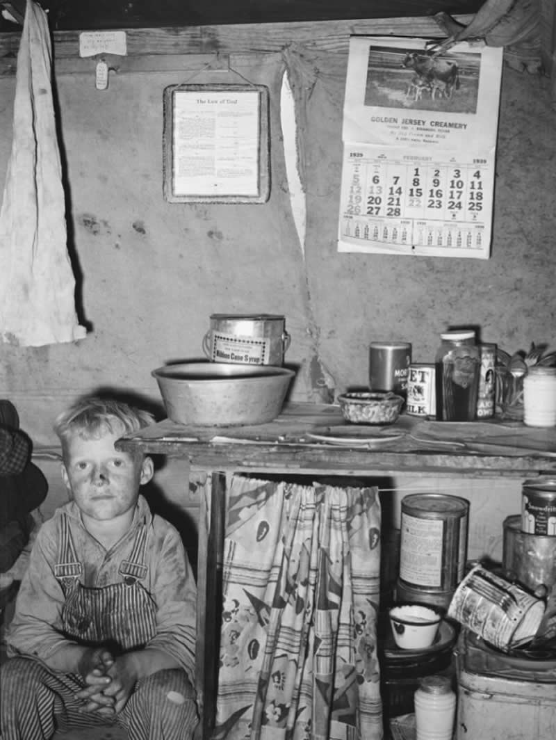 Laborer&rsquo;s child sits by the kitchen cabinet in a tent home, Edinburg, Texas, 1939.