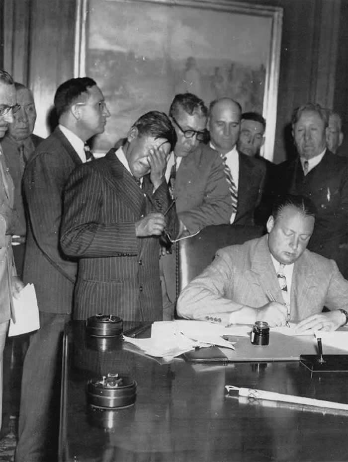 Tribal Chairman George Gillette weeping as Secretary of Interior J. A. Krug signs the contract for the Garrison Dam. 1948