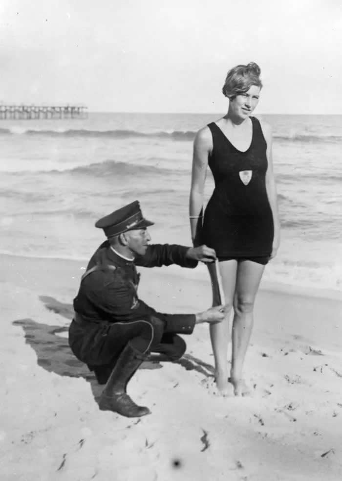Smokey' Buchanan from the West Palm Beach police force, measuring the bathing suit of Betty Fringle on Palm Beach, to ensure that it conforms with regulations introduced by the beach censors.
