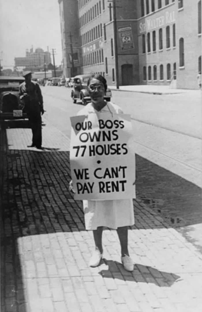 A woman holds a sign reading, &ldquo;Our boss owns 77 houses, we can&rsquo;t pay rent.&rdquo; Taken in 1938 in Richmond, Virginia, this photo shows her picketing for higher wages while working at a tobacco company.