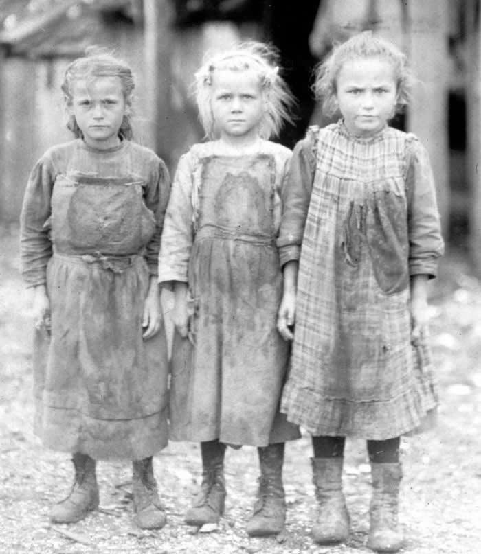 (From left to right) 6-year-old Josie, 6-year-old Bertha, and 10-year-old Sophie who all work as oyster shuckers at a canning company at Port Royal, South Carolina, circa 1911.